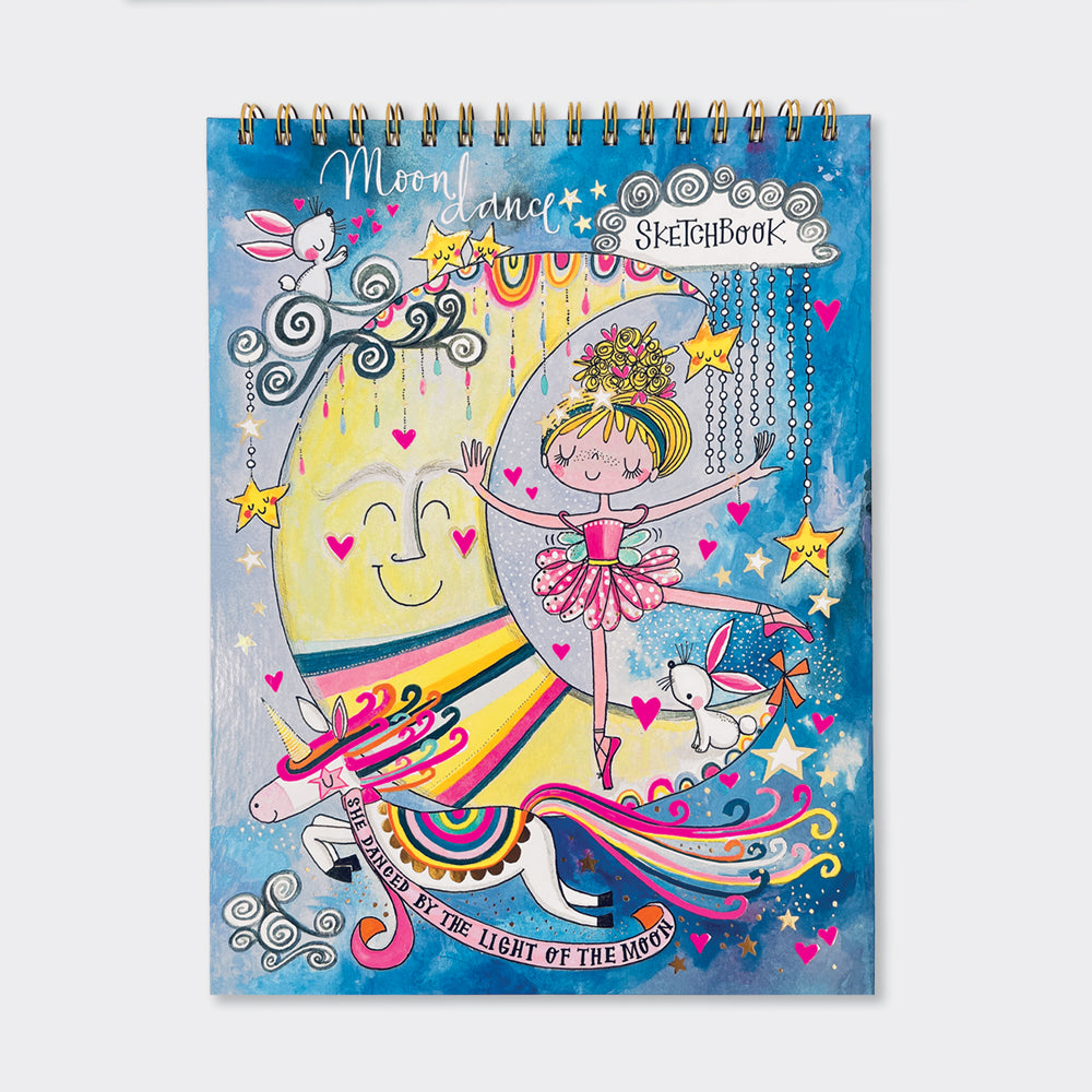 A colorful sketchbook with a whimsical design featuring a ballerina, moon, stars, and the text 'Moondance'. The cover is spiral bound and has gold foil finish.