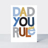Father's Day Hero card in white with 'Dad You Rule' text, a small gold foil crown, and colourful block lettering.