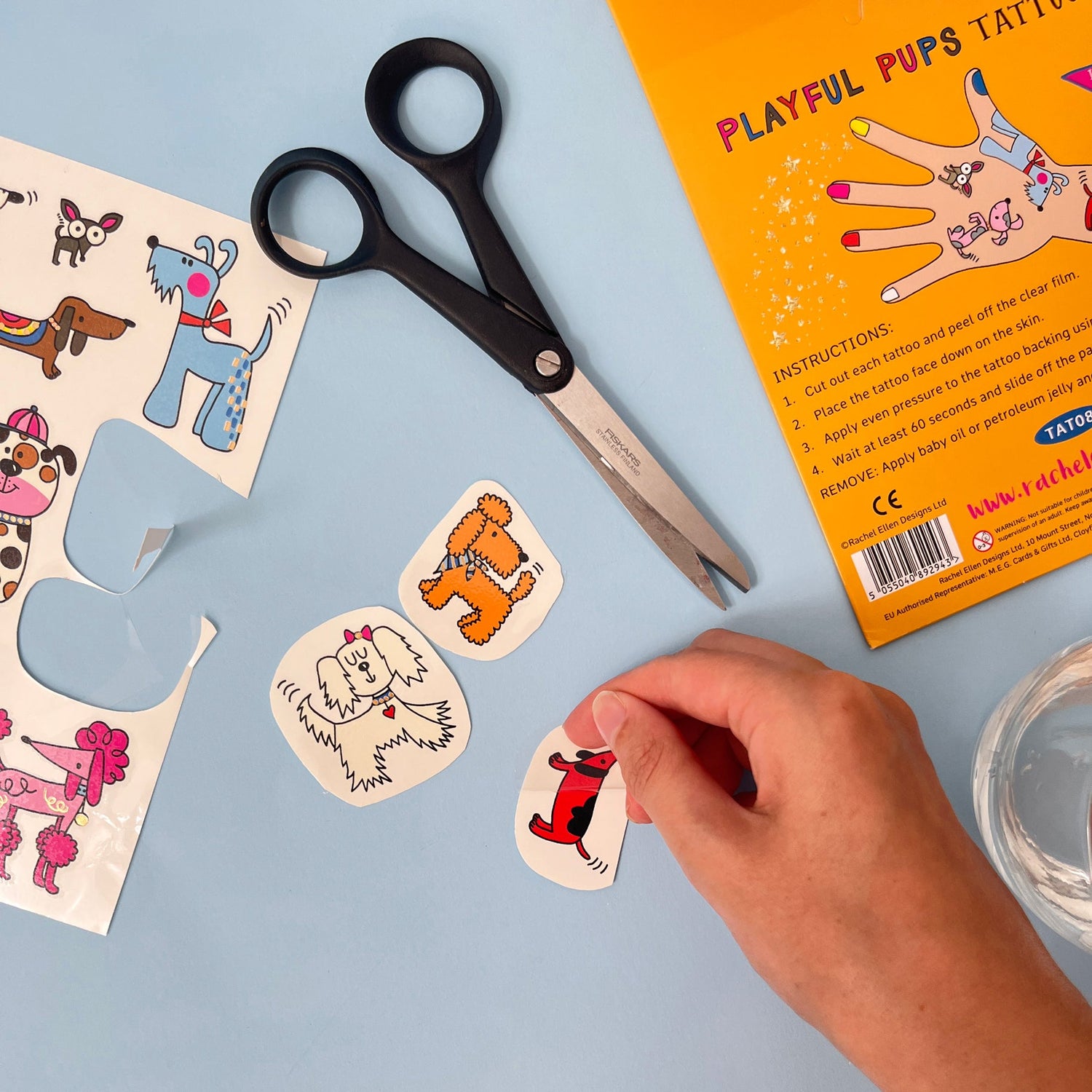 Playful pups tattoo set with scissors and packaging on a blue background